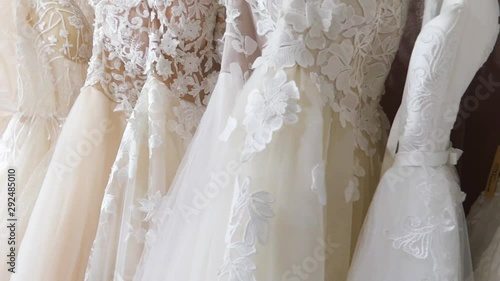 Rack with many beautiful wedding dresses close up.
