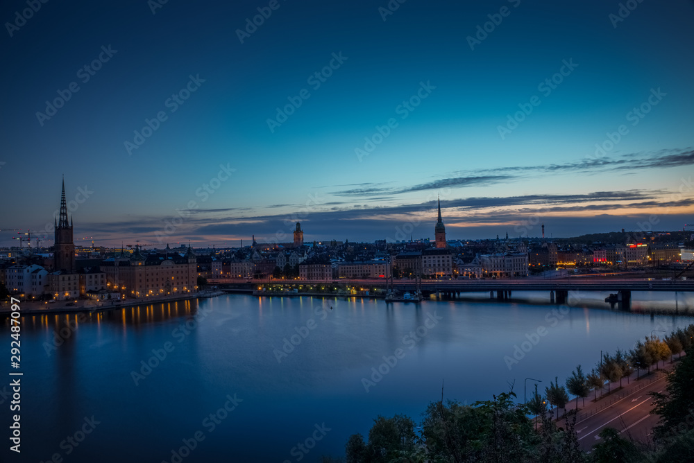 A colorful sunrise over Stockholm with the lights reflecting on the calm water of the sea - 11