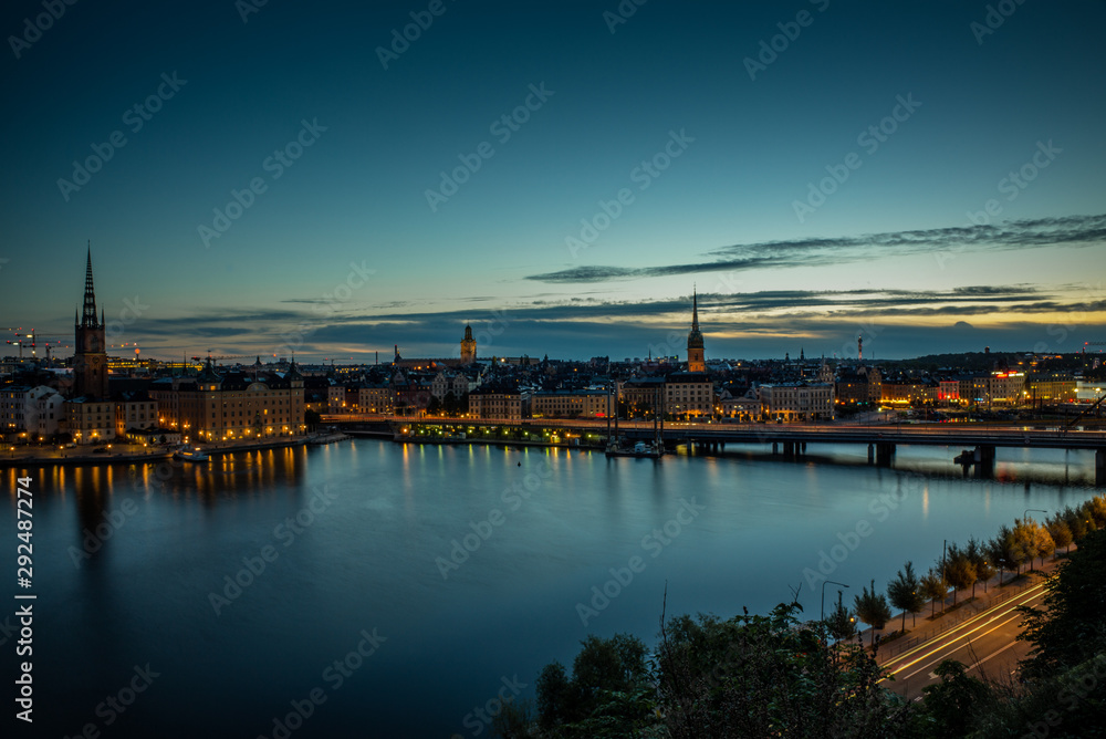 A colorful sunrise over Stockholm with the lights reflecting on the calm water of the sea - 3