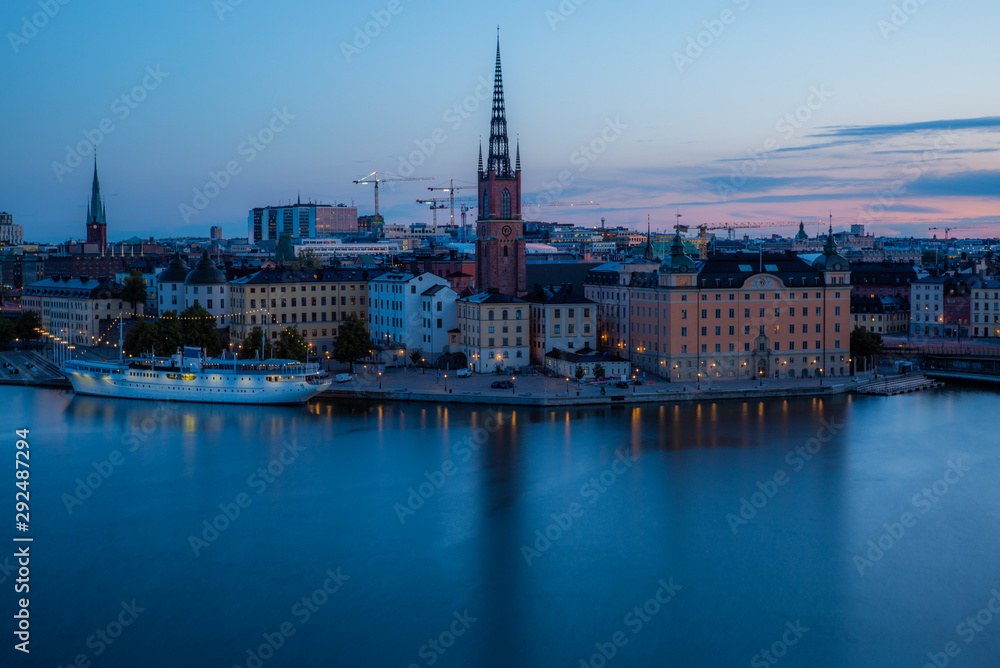 A colorful sunrise over Stockholm with the lights reflecting on the calm water of the sea - 5
