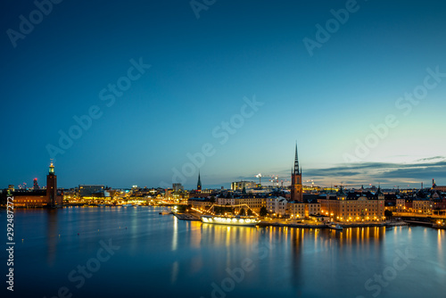 A colorful sunrise over Stockholm with the lights reflecting on the calm water of the sea - 2