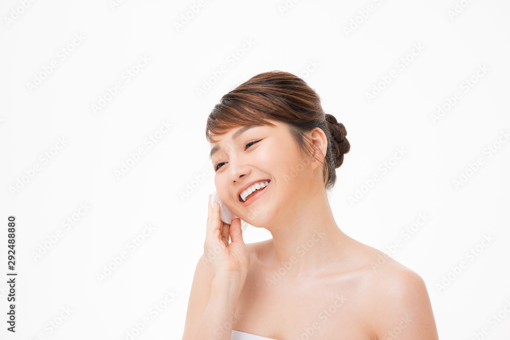 Asian woman with fair perfect healthy glow skin hands hold cotton pad cleansing face isolated on white Asian woman with fair perfect healthy glow skin hands hold cotton pad cleansing face isolated on white