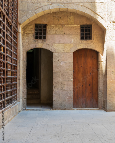 Exterior brick stone passage with two adjacent vaulted wooden grunge doors © Khaled El-Adawi