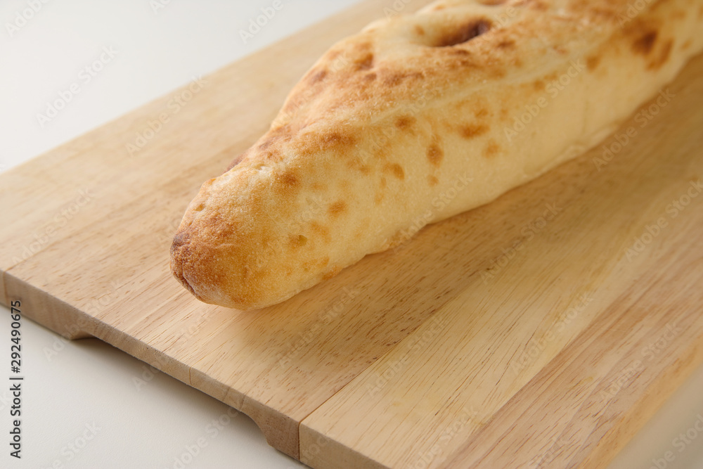 Diagonal view of Georgian traditional freshly baked bread shoti on wooden board Diagonal view of Georgian traditional freshly baked bread shoti on wooden board