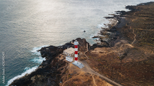 Punta Abona lighthouse. Landscape overlooking the ocean. Sunset. The water is shiny. Aerial. Tenerife Island, Spain