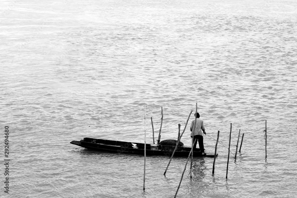 Old fisherman on the boat in lake