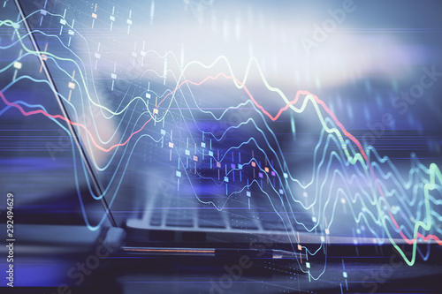 Forex graph hologram on table with computer background. Multi exposure. Concept of financial markets.