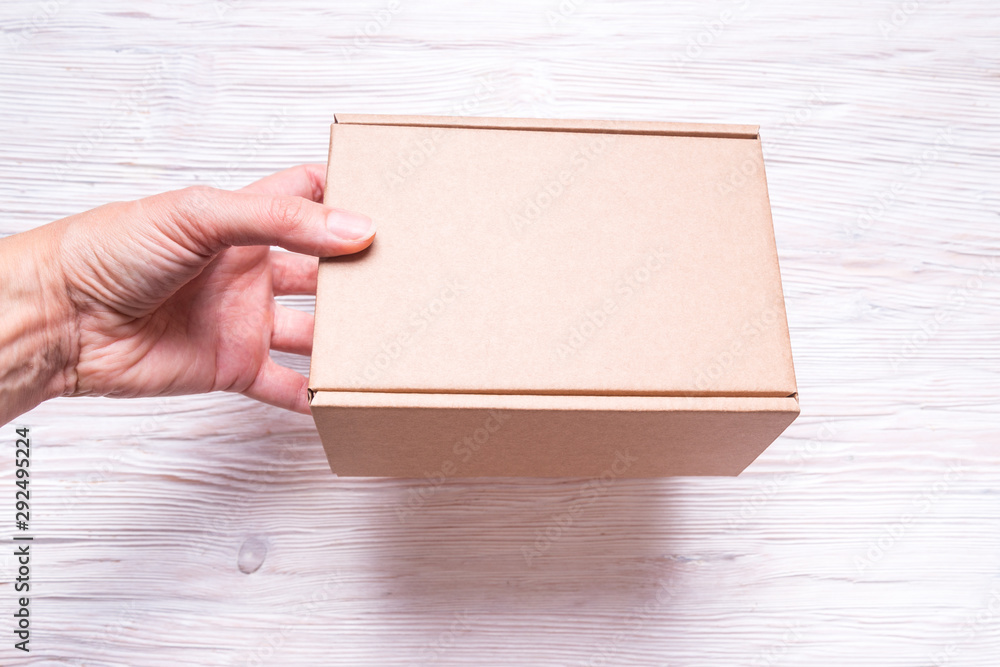 Cardboard box with handle on wooden background Cardboard box with handle on wooden background