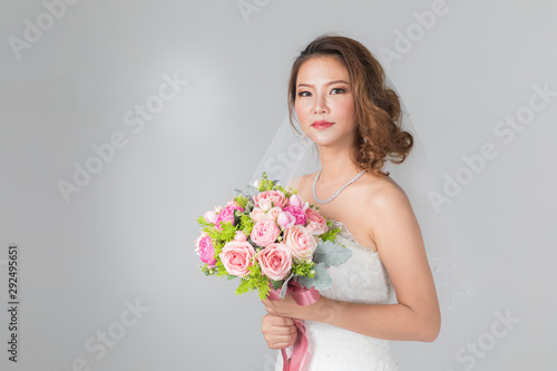 Asian bride standing and holding a bouquet..