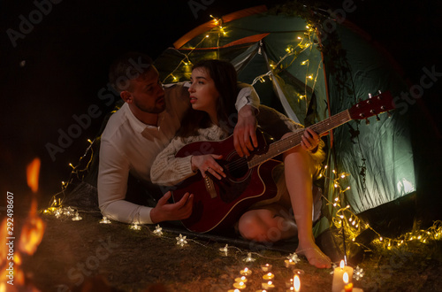 couple in a tent with a guitar