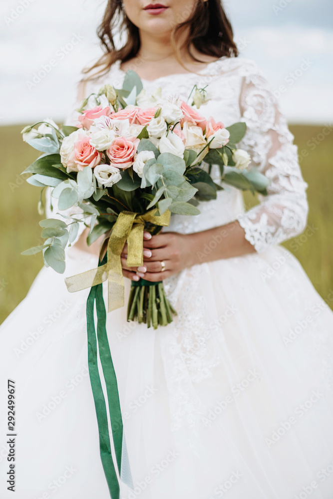 Wedding bouquet in bride's hands. Close-up. Wedding Accessories Bride