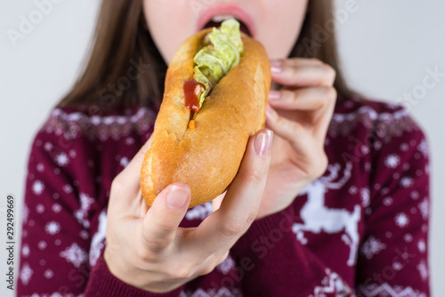 Over eating concept. Cropped closeup photo of crazy hungry girl trying to eat all the sandwich in her hands isolated grey background