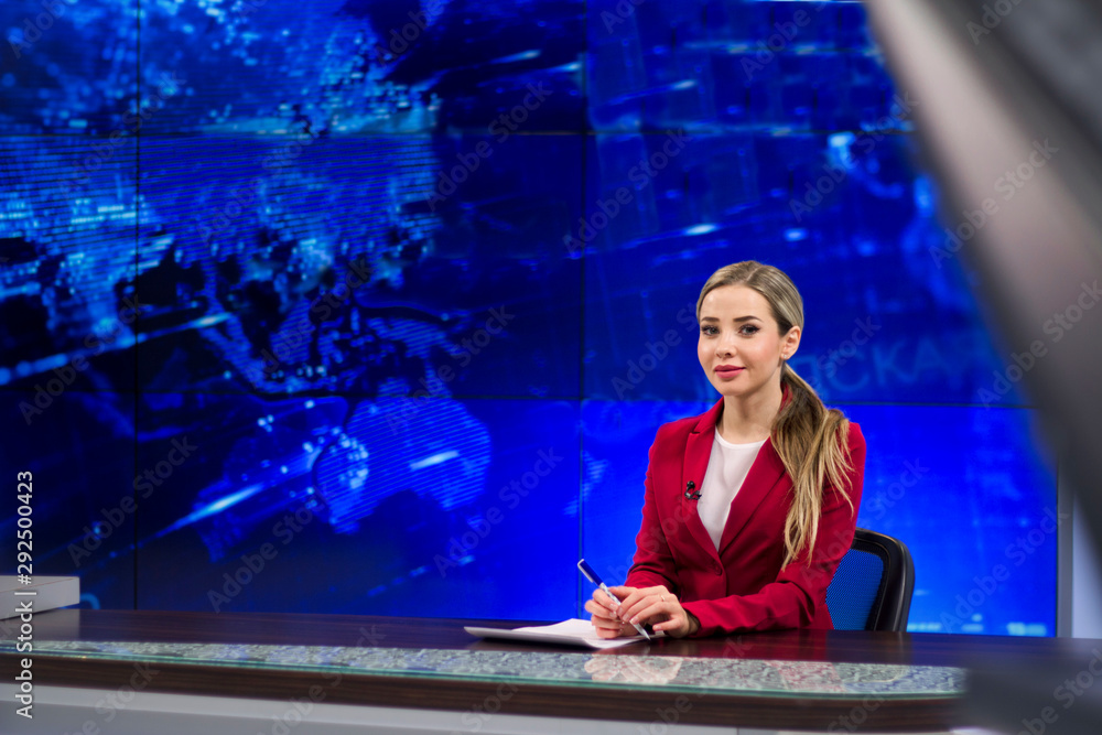 News anchor in the TV Studio . Beautiful girl reading the news, on a blue screen background