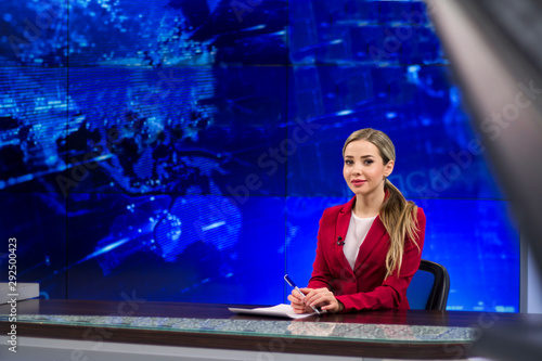 Obraz na płótnie News anchor in the TV Studio . Beautiful girl reading the news, on a blue screen background w salonie