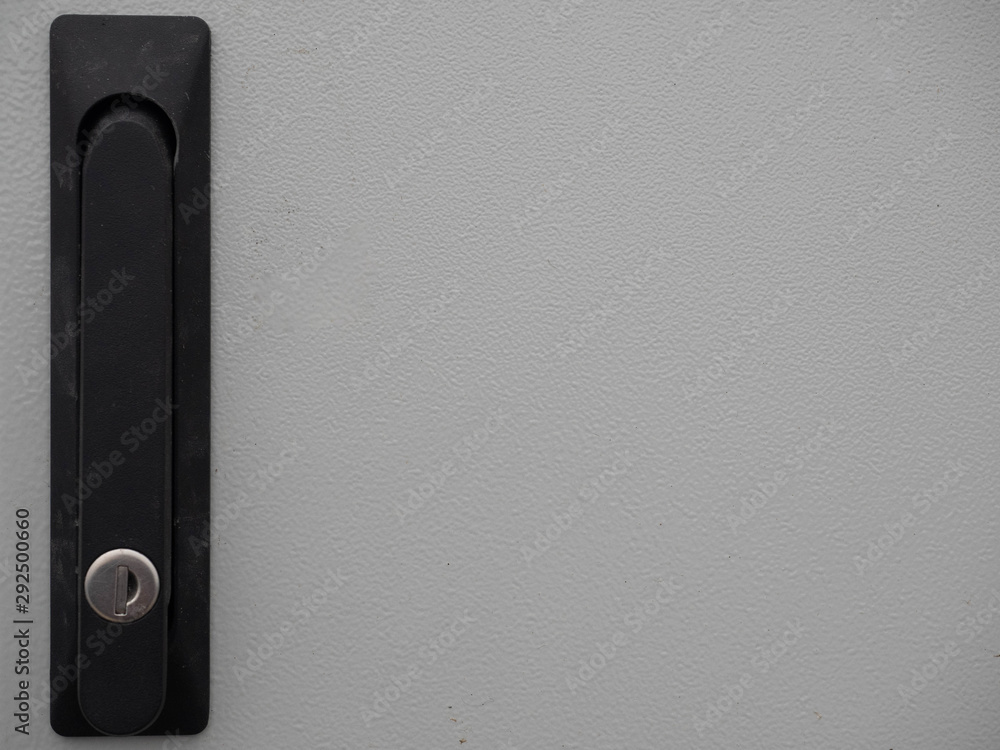 Plastic door handle have a keyhole on grey metal door Plastic door handle have a keyhole on grey metal door