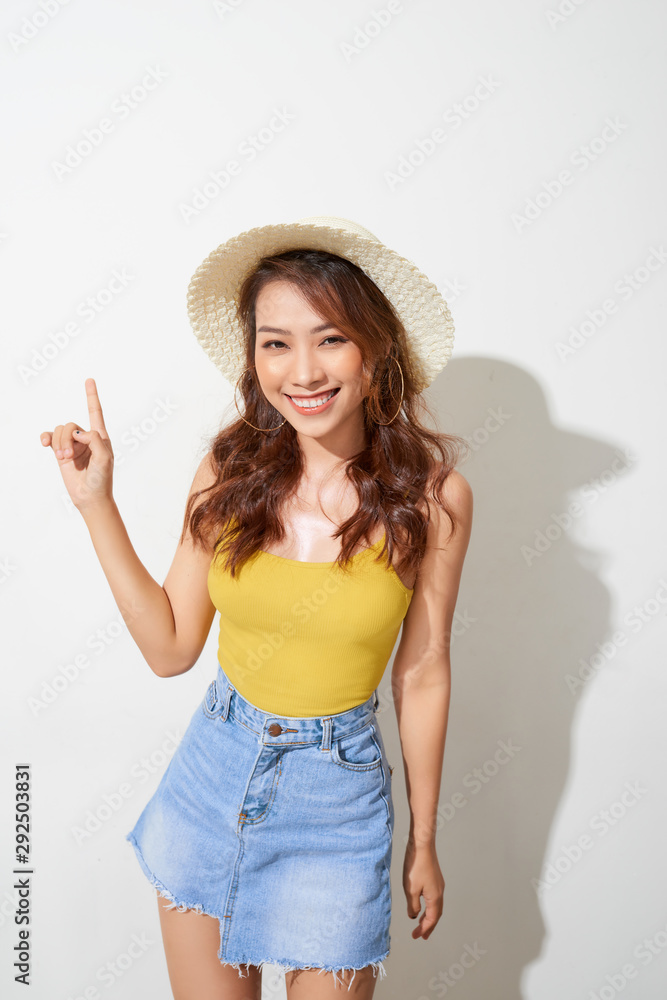 Young Asian woman wearing round hat with expression of surprise isolated on white background.