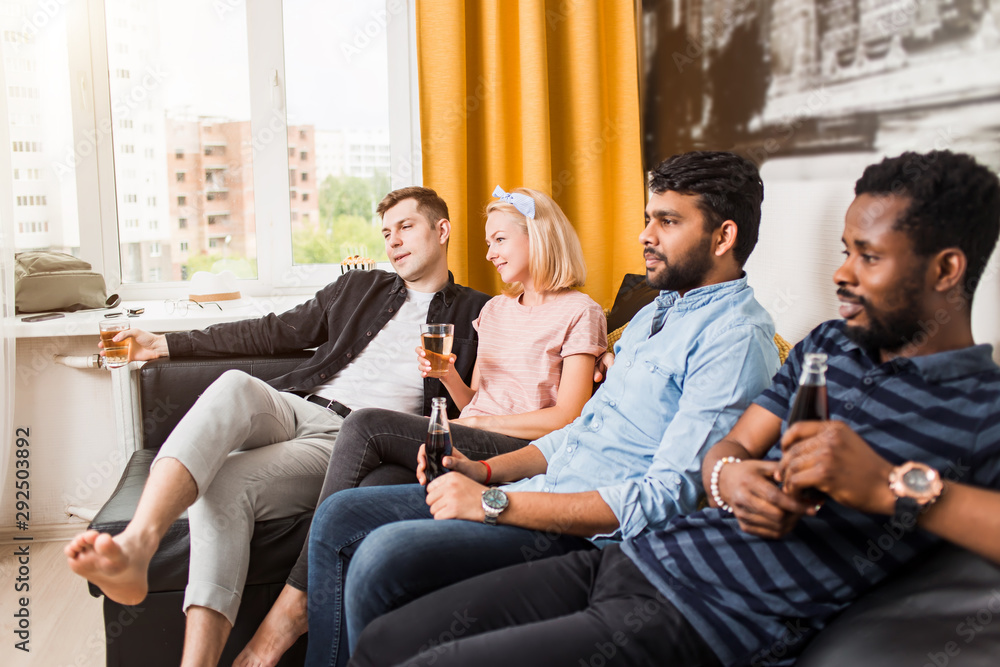 Group of friends watching television at home together Group of friends watching television at home together