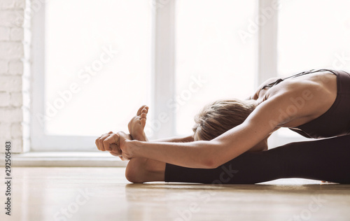 Canvas Print Close up of young woman practicing yoga at class, working out, wearing sportswear, indoor