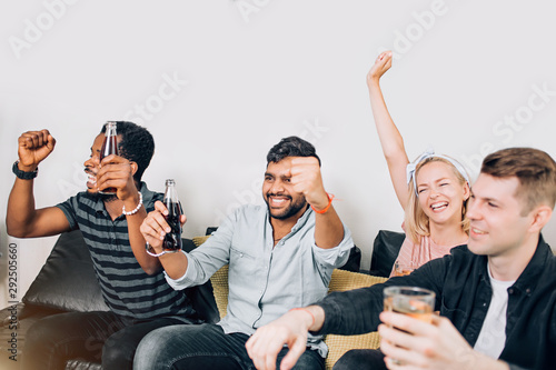 Group of friends watching television at home together