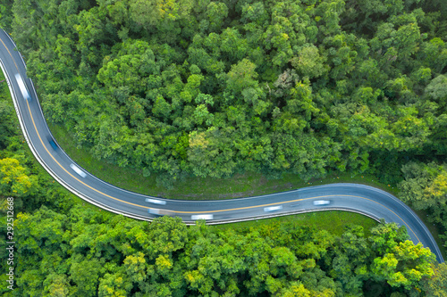 Aerial top view of beautiful road through the green forest, road going through forest from above. © RoBird