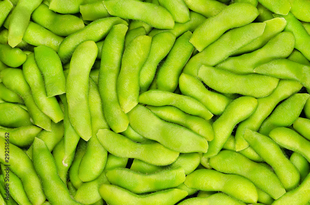 Edamame, green soybeans in the pod, background. Unripe soya beans, also Maodou. Glycine max, a legume, edible after cooking and a rich protein source. Closeup, macro food photo. Edamame, green soybeans in the pod, background. Unripe soya beans, also Maodou. Glycine max, a legume, edible after cooking and a rich protein source. Closeup, macro food photo.
