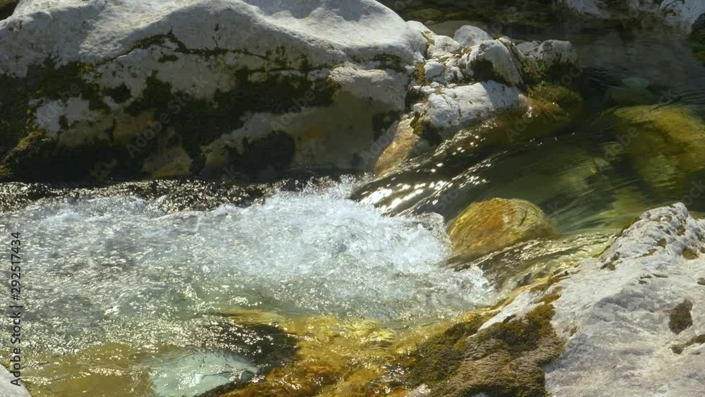 CLOSE UP: Crystal clear mountain stream in Bohinj, Slovenia flows along the rocky riverbed on a sunny day. Glassy river shimmers in warm autumn sunlight as it flows through serene nature in Slovenia. CLOSE UP: Crystal clear mountain stream in Bohinj, Slovenia flows along the rocky riverbed on a sunny day. Glassy river shimmers in warm autumn sunlight as it flows through serene nature in Slovenia.