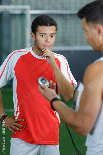 football player looking disappointed as coach reveals time on stopwatch