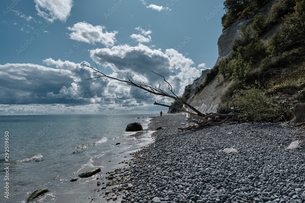 Blick am Kiesstrand auf die Ostsee und dem sonnigen bewölktem Himmel am Fuße von weißen hoch aufragenden Kreidefelsen Blick am Kiesstrand auf die Ostsee und dem sonnigen bewölktem Himmel am Fuße von weißen hoch aufragenden Kreidefelsen