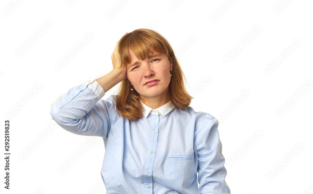 Young girl with ginger hair and freckles touching her head as having a headache our feeling tired, overwhelmed with noises. White background, copy space, isolated model. Young girl with ginger hair and freckles touching her head as having a headache our feeling tired, overwhelmed with noises. White background, copy space, isolated model.