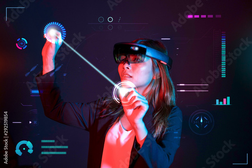 Business woman try vr glasses hololens in the dark room. Young asian girl experience mixed reality. Future technology concept. photo