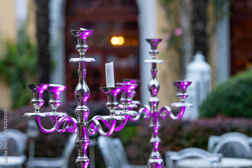 Metal candelabra lit by purple lights in the middle of the park of a  mansion Stock Photo | Adobe Stock