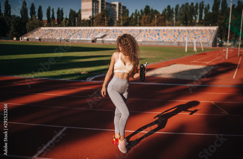 sports beautiful girl at the stadium with a bottle of water