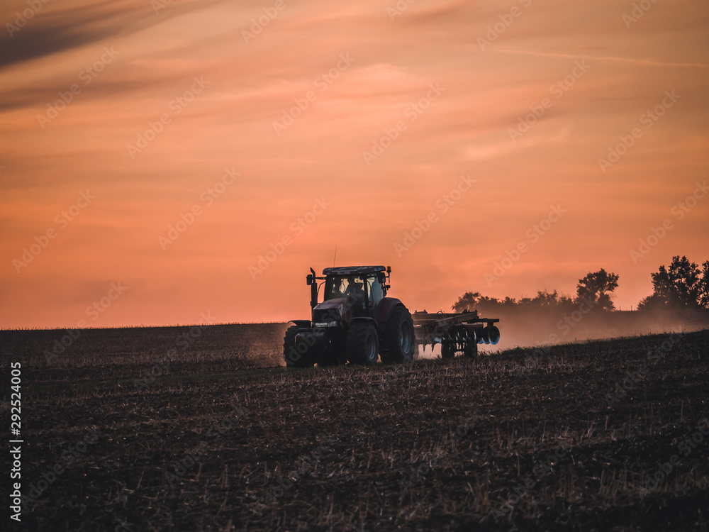 Tractor on filed by sunset. Tractor on filed by sunset.