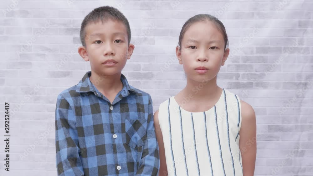 Emotional close up portrait of asian boy and girl standing and looking at the camera. Emotional close up portrait of asian boy and girl standing and looking at the camera.