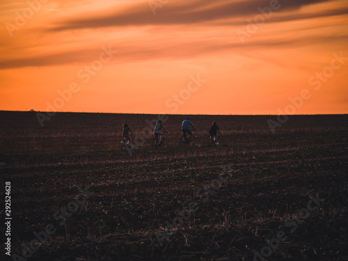 Biker on field by sunset. © Peter