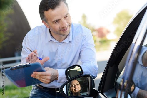 Fotografi instructor in driving school writing down results of exam