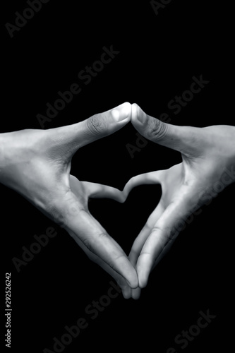Close up shot of pair of human hands with open hands stretched and doing Yoni Mudra or Feminine adi shakti hand gesture isolated on black background.
