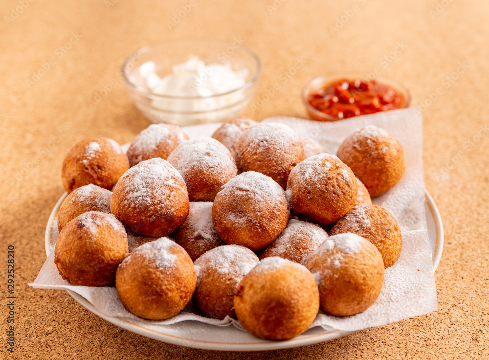 Round doughnuts, sprinkled with powdered sugar, lie on a plate Round doughnuts, sprinkled with powdered sugar, lie on a plate