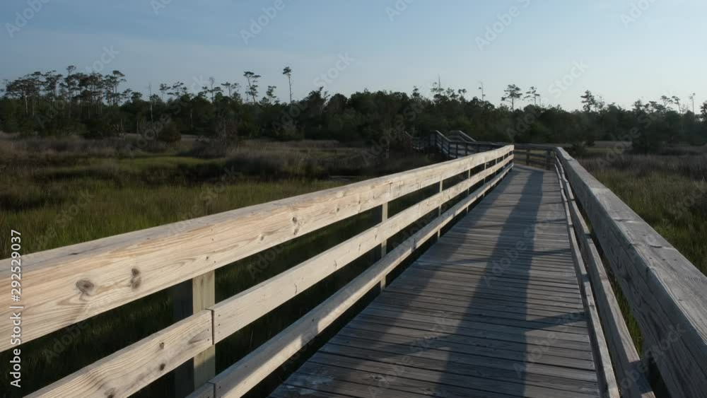 nature trail walkway through a spartina grass marsh near Topsail Beach, North Carolina. Spartina Marches protect the mainland from damage by ocean storms and hurricanes. nature trail walkway through a spartina grass marsh near Topsail Beach, North Carolina. Spartina Marches protect the mainland from damage by ocean storms and hurricanes.