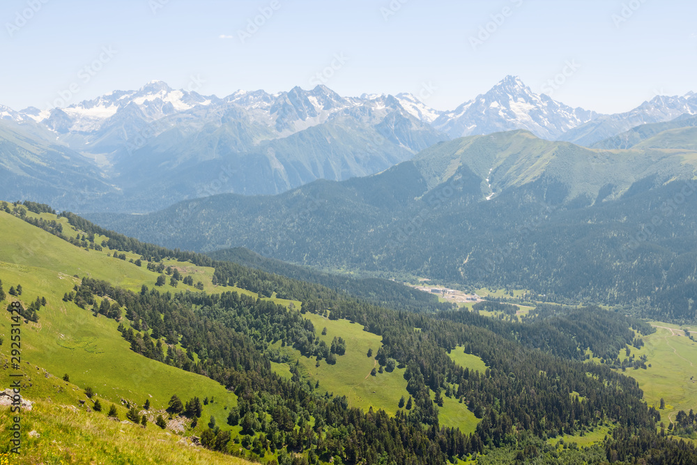 beautiful green mountain valley, mountain chain in a snow, bright summer day mountain scene