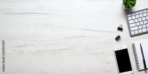 White desk office with laptop, smartphone and other work supplies with cup of coffee. Top view with copy space for input the text. Designer workspace on desk table essential elements on flat lay