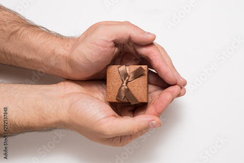 Brown jewelry box in man hands. Present. White background