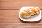 Beef steak sandwich with cheese and tomato, isolated on wooden background