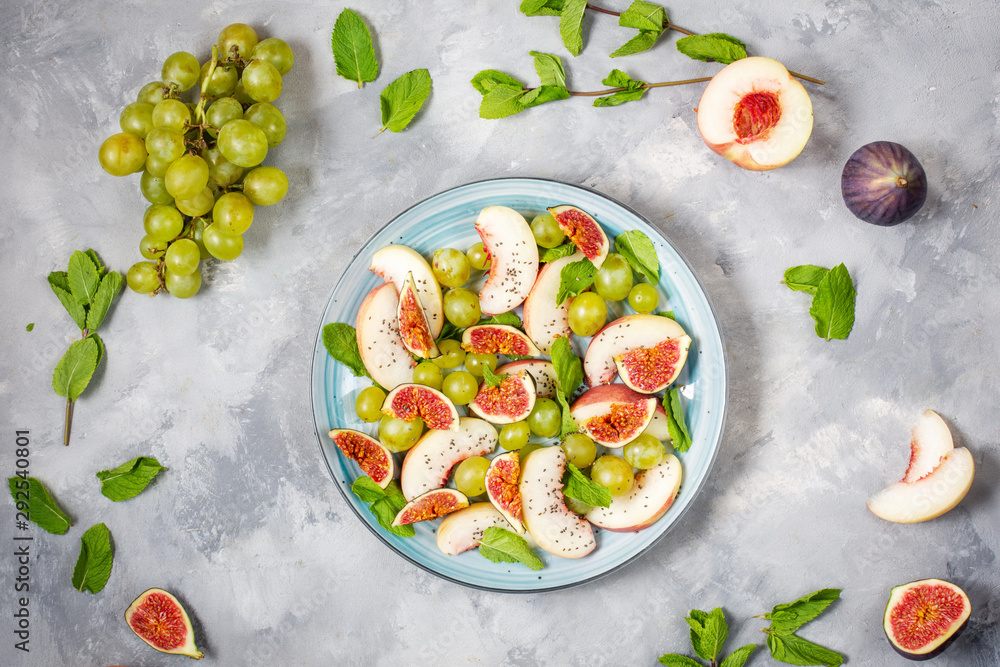 Fresh fruit and berry salad with grapes, fig and peach on concrete background. Healthy food. Fresh fruit and berry salad with grapes, fig and peach on concrete background. Healthy food.