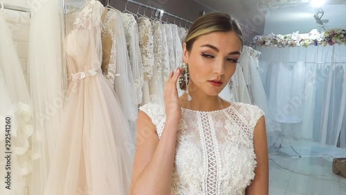 Beautiful young bride in a wedding dress posing in a wedding salon.