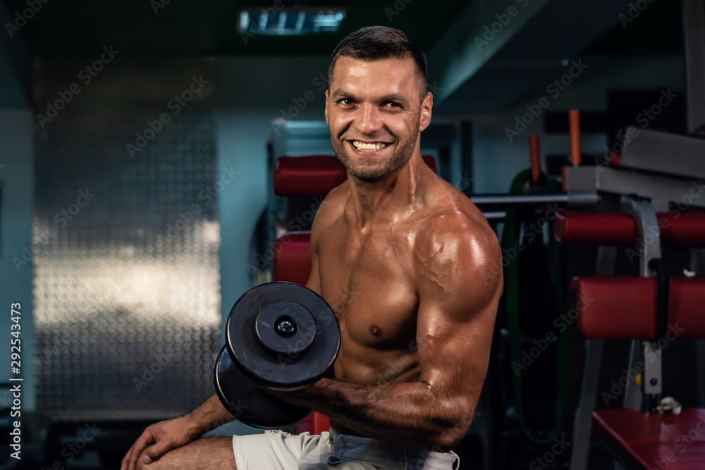 smiling handsome man. muscular bodybuilder doing exercise on bars in the gym. a handsome, sporty, sexy guy with a abs training in the gym. fitness, bodybuilding, nutrition, healthy lifestyle smiling handsome man. muscular bodybuilder doing exercise on bars in the gym. a handsome, sporty, sexy guy with a abs training in the gym. fitness, bodybuilding, nutrition, healthy lifestyle