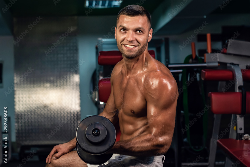 muscular bodybuilder doing exercise on bars in the gym. a handsome, sporty, sexy guy with a abs training in the gym. fitness, bodybuilding, nutrition, healthy lifestyle muscular bodybuilder doing exercise on bars in the gym. a handsome, sporty, sexy guy with a abs training in the gym. fitness, bodybuilding, nutrition, healthy lifestyle