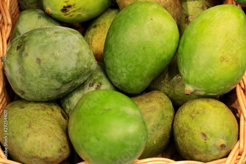 Fresh green mango lying on the counter in the supermarket. Fruit background. 