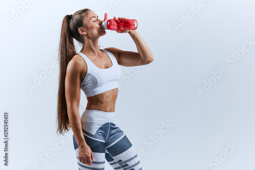 tired sweaty good looking girl with ponytail having a rest during training. close up side view photo. copy space.