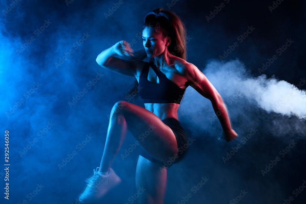 flexible athlete girl concentrated on training exercise, close up side view photo. isolated black background, studio shot, motivation, strength training
